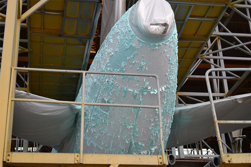 Opération de décapage peinture sur le fuselage d'un avion